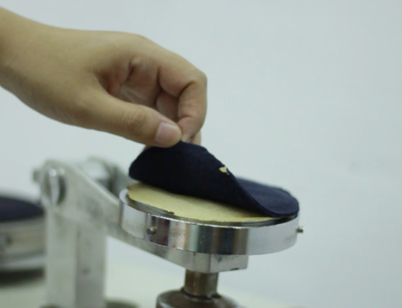 A person inspecting the fabric for Resistance to balling